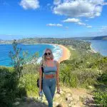 Fit woman in stylish sportswear enjoys panoramic scenic viewpoint on a 1 Day Home Away Location Tour, ideal for adventure seekers.