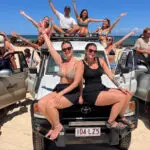 a group of friends having fun with on a 4wd on K'gari Fraser Island