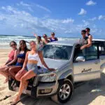 a group of friends having fun with on a 4wd on K'gari Fraser Island