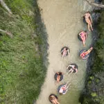 a group of friends having fun with inflatable tubes on a river