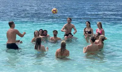 a group of friends having fun with a ball in a lake