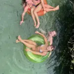 a group of friends having fun with inflatable tubes on a river