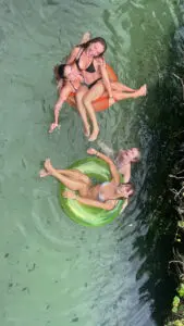 a group of friends having fun with inflatable tubes on a river