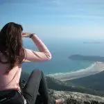 Experience breathtaking views as a woman admires the sea from a cliff on a 1 Day Wilsons Promontory Tour with Go West Tours.