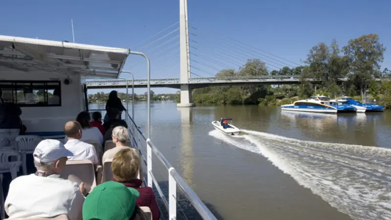 Visitors aboard a riverboat admire a passing speedboat whilst enjoying a scenic return cruise to Lone Pine Koala Sanctuary in Brisbane.