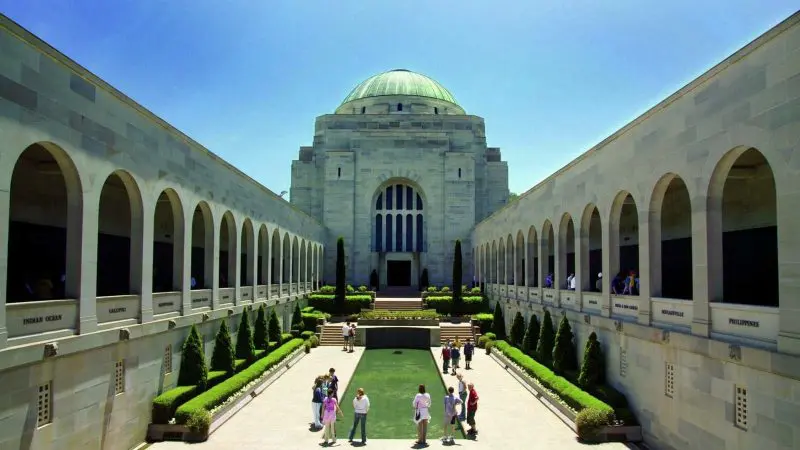 Visitors explore the impressive domed memorial courtyard, a must-see attraction on a Canberra day trip from Sydney.