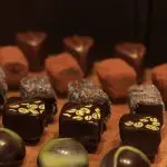 Premium selection of gourmet chocolates and truffles inspired by Yarra Valley Grazing Tour, beautifully displayed on rustic wood.