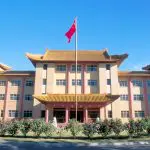 Impressive Chinese-style building with red flag under clear blue sky, ideal for a Canberra day trip from Sydney sightseeing tour.