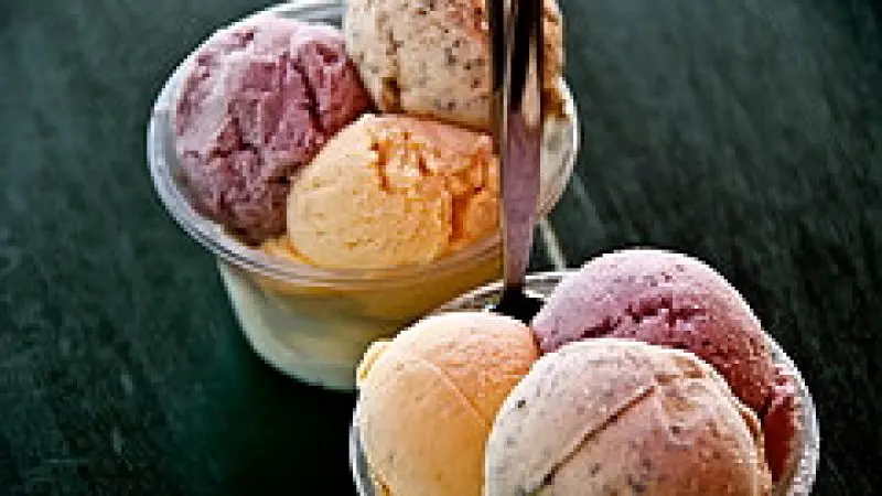 Two cups of gourmet ice cream, each with three vibrant flavours, reminiscent of a Premium Daintree Cape Tribulation Day Tour treat.