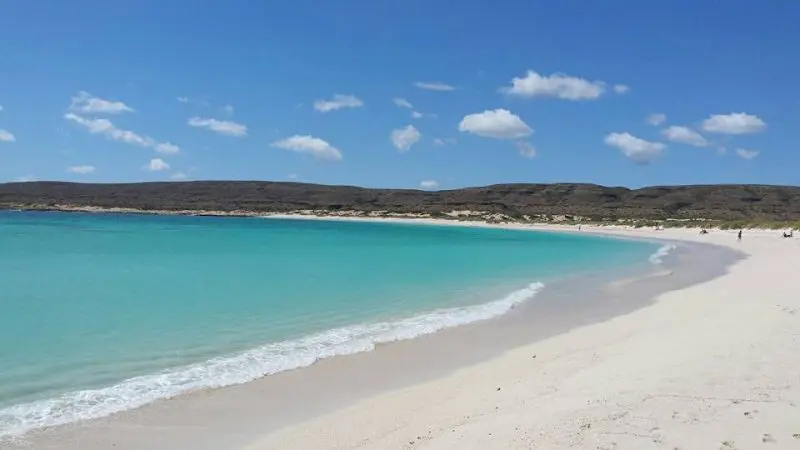 Pristine turquoise waters and powdery white sand beach beneath clear blue skies on the 8 Day Perth to Exmouth Return Tour adventure.