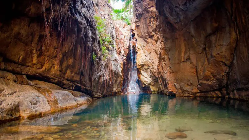 Stunning small waterfall pours into a crystal-clear, rocky pool—must-see highlight on the 10 Day Broome to Darwin Tour in Kimberley.