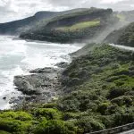 Experience the stunning Great Ocean Road: a scenic coastal drive with ocean views, lush green hills, and Go West’s 1 day guided tour.