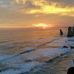 Breathtaking Great Ocean Road sunset tour with dramatic rock formations, gentle ocean waves, and pristine sandy coastline views.