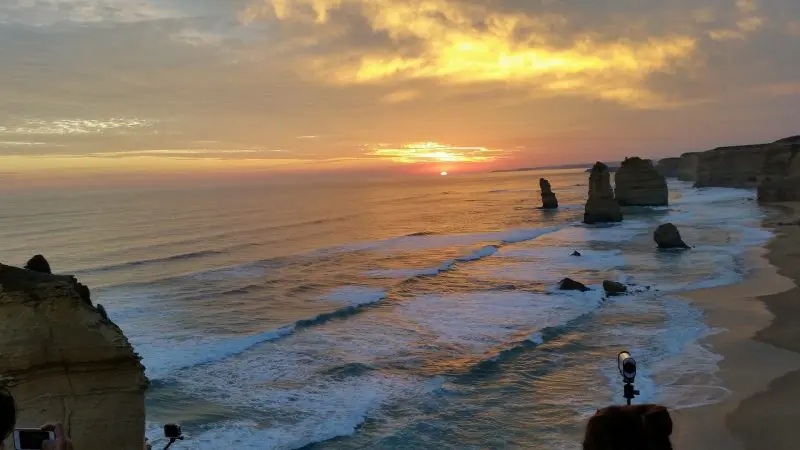 Breathtaking Great Ocean Road sunset tour with dramatic rock formations, gentle ocean waves, and pristine sandy coastline views.