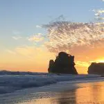 Breathtaking sunset over the ocean on a 1 Day Great Ocean Road Tour by Go West Tours—golden waves shimmer on sandy Australian shores.