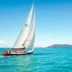 Experience the ultimate 2 Day, 2 Night Condor Whitsunday Sailing adventure gliding over turquoise waters beneath clear skies and scenic hills.