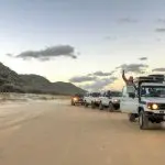 Experience five powerful 4WD vehicles exploring sandy shores on a top-rated 3 Day K'gari Fraser Island Tag Along Adventure; leader waves.