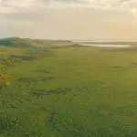 Stunning aerial shot of Noosa Everglades with rolling hills, lush greenery, serene lake—ideal for top-rated Everglades Eco Safaris tours.