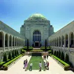 Visitors explore the Australian War Memorial courtyard in Canberra on a Sydney day trip, enjoying sunny skies and iconic scenery.