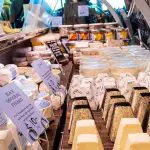 Assorted artisanal cheeses in diverse shapes arranged in a glass deli display case on a relaxed Yarra Valley Winery Tour experience.
