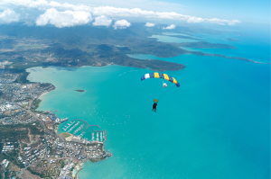 Picture of skydive in Airlie Beach with parashute gliding over the skies in Airlie beach with views of the Whitsundays tropical islands.