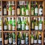 Rows of green and brown empty wine bottles line shelves, evoking memories of a Hunter Valley Scenic Wine Tour experience.