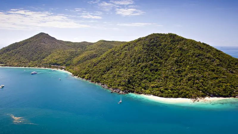 Discover Fitzroy Island’s lush greenery, twin hills, clear turquoise waters, and boats—ideal for your ultimate Half-day Tour.