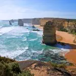 Majestic limestone stacks tower above vibrant turquoise waves on the Great Ocean Road Day Tour with Go West, a top-rated adventure.