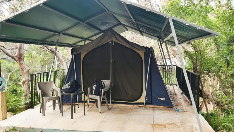 Spacious tent beneath a metal roof with rows of plastic chairs at Dingos site for the 2 Day K'gari Fraser Island Tag Along Adventure.