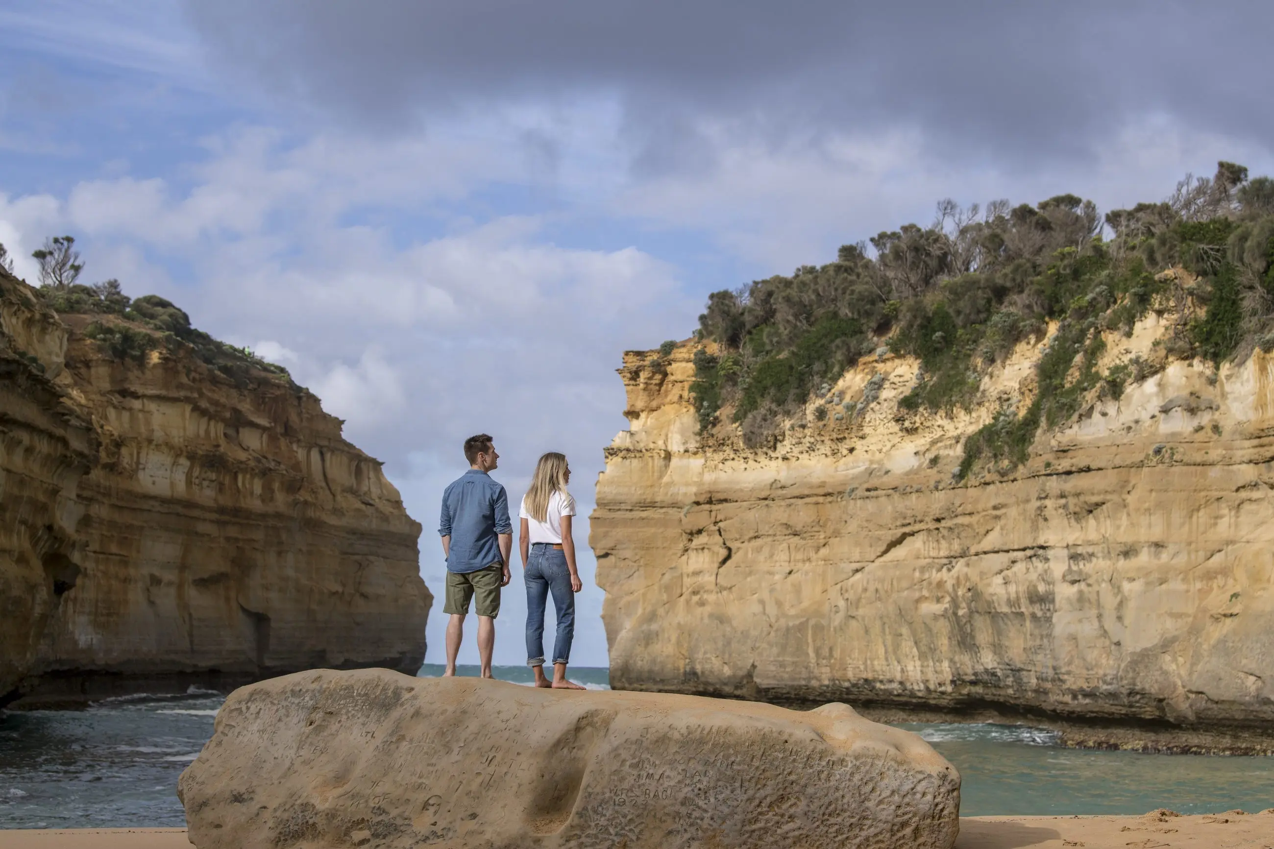 A couple stands atop a scenic rock on a 2 Day Great Ocean Road Grampians Overnight Escape tour departing from Melbourne, Australia.