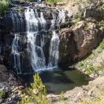 Experience the breathtaking sight of a tall waterfall flowing over rugged cliffs on the 3 Day Great Ocean Road Grampians Explorer tour.