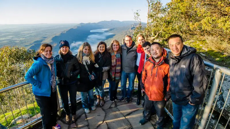 Happy group enjoying panoramic coastal views on a 2-day Great Ocean Road Melbourne to Adelaide tour, perfect for travel lovers.