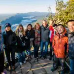 Travellers enjoying panoramic mountain vistas on the 3 Day Great Ocean Road Grampians Explorer tour from Melbourne, smiling at lookout.