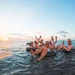 a group of friends having fun in a floating ring on a trip to Fiji