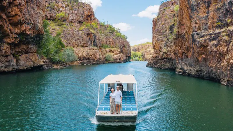 A tour boat with adventurers navigates scenic Katherine Gorge on a 5 Day Kakadu and Litchfield 4WD Adventure from Darwin, Australia.