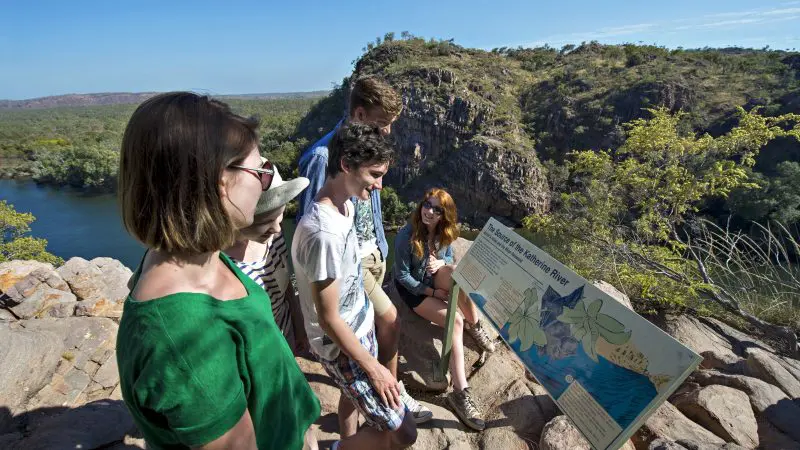 Group of five admiring breathtaking river views on the 1 Day Katherine Gorge Cruise, scenic hills and rugged cliffs in the background.
