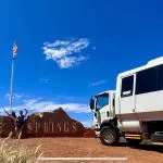 Travellers pose in front of the Alice Springs sign, ready to embark on a 2-day Uluru and Kata Tjuta rock tour from Ayers Rock Yulara.