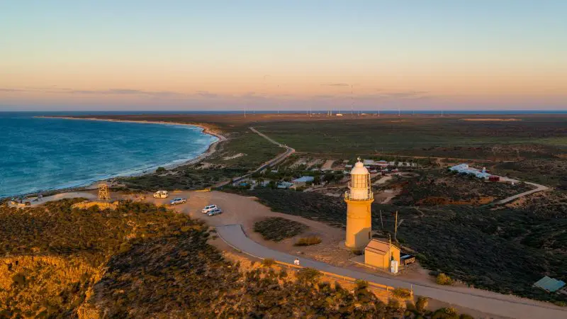 Stunning aerial view of a coastal lighthouse at sunset on the 6 Day Perth to Exmouth Coral Coaster tour, Western Australia.