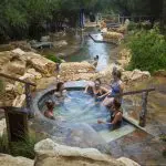 Relax at Peninsula Hot Springs as six guests enjoy a stone spa; includes 1 Day Spa Entry and convenient shuttle bus service.