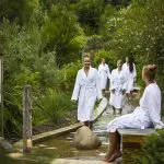 Relaxing at Peninsula Hot Springs: five women in white robes enjoy a luxury footbath and spa entry via 1 Day Shuttle Bus.