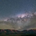 Spectacular star-studded night sky above rugged mountains and sweeping grasslands on the 7 Day Adelaide to Uluru Adventure tour.