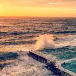 Stunning ocean pool with waves crashing at sunset, must-see attraction on the 10 Day Oz Intro Sydney to Brisbane tour.