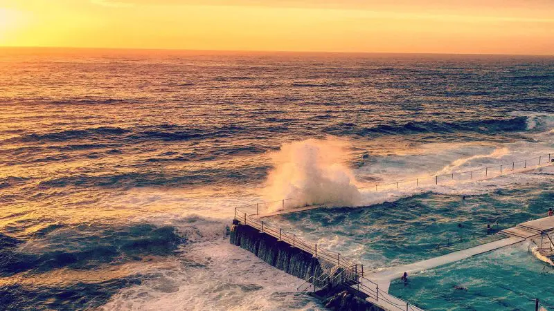Stunning ocean pool with waves crashing at sunset, must-see attraction on the 10 Day Oz Intro Sydney to Brisbane tour.