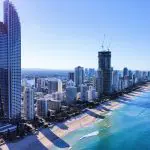 Stunning aerial view of Sydney to Brisbane coastline, featuring towering skyscrapers and golden sandy beaches on the Oz Intro 10 Day tour.