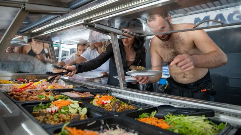 Guests help themselves to a freshly prepared buffet at Reef Magic Outer Barrier Reef Pontoon, enjoying casual seafront dining.