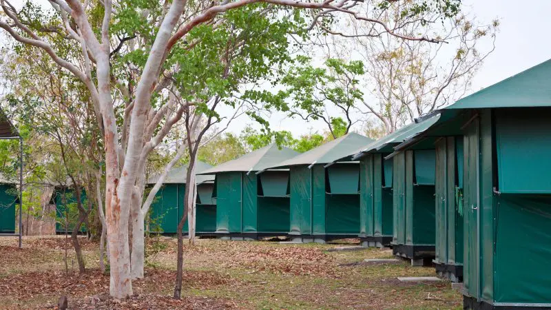 Green canvas tents neatly aligned at a scenic campsite on the Darwin to Perth Adventure Combo, perfect for outdoor enthusiasts in Broome.