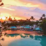 Luxury swimming pool with loungers and parasols at sunset, ideal for relaxing after a Kgari 2 Day Tour Ex Hervey Bay experience.