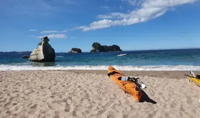 Vibrant yellow kayak resting on a sandy beach with gentle sea waves, perfect for kayaking adventures and seaside relaxation.