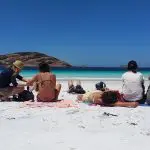 Six travellers relax on pristine white sand at Esperance Beach, part of Untamed Escapes’ 6 Day Margaret River Adventure Tour in Australia.