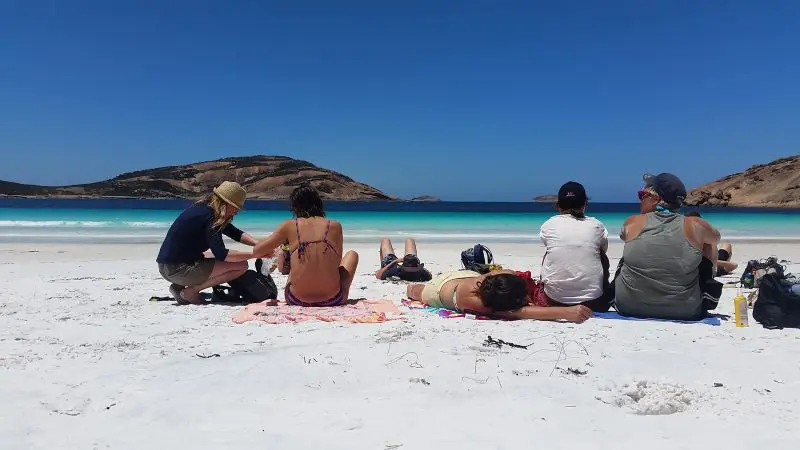 Six travellers relax on pristine white sand at Esperance Beach, part of Untamed Escapes’ 6 Day Margaret River Adventure Tour in Australia.